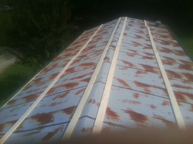 Rusted metal roof panels with new wood purlins before replacement — Storm Damage Roof Repair in Paterson by Roofing Brothers